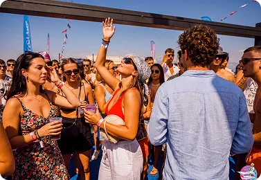 Guests dancing on deck with their hands in the air